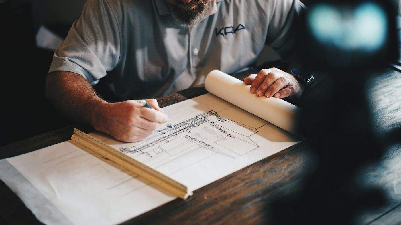 An architect marking up construction drawings with a scale rule